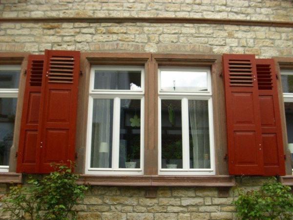 Sanierung der Fenster in weiß mit roten Klappläden 