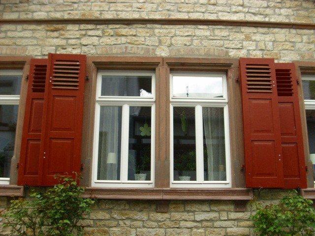 Sanierung der Fenster in weiß mit roten Klappläden